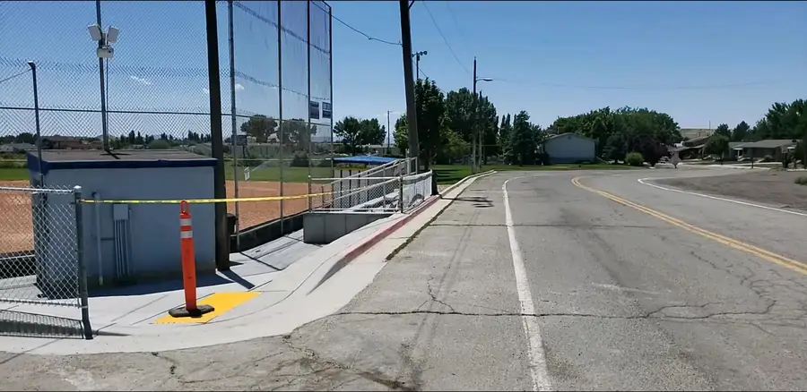 Street view of the new ballpark sidewalk, ramp and bleacher access beside the backstop