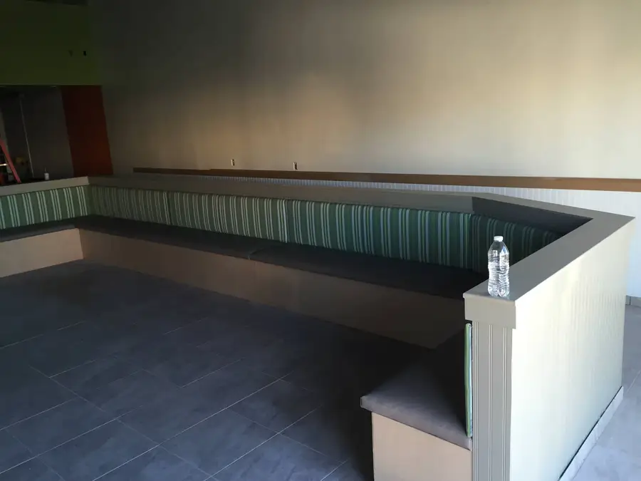 New built-in booth seating with green striped backs wrapping the dining room