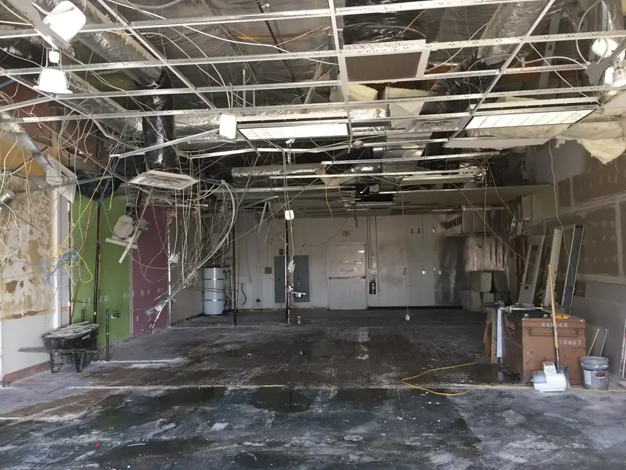 A retail space stripped to its open ceiling grid and bare floor, ready for a build-out