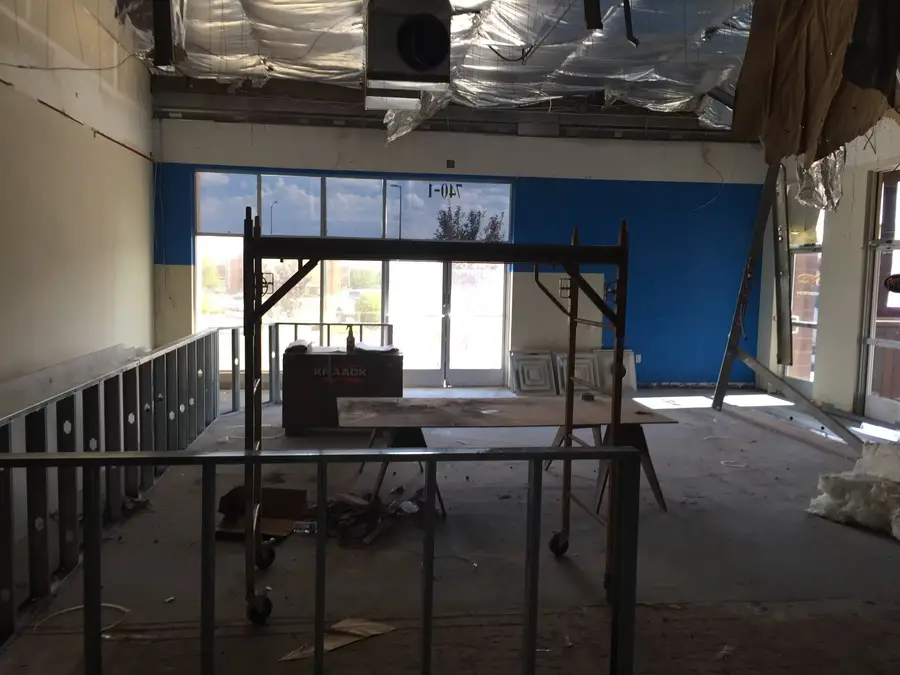 Steel stud walls and rolling scaffolding inside the storefront windows during framing
