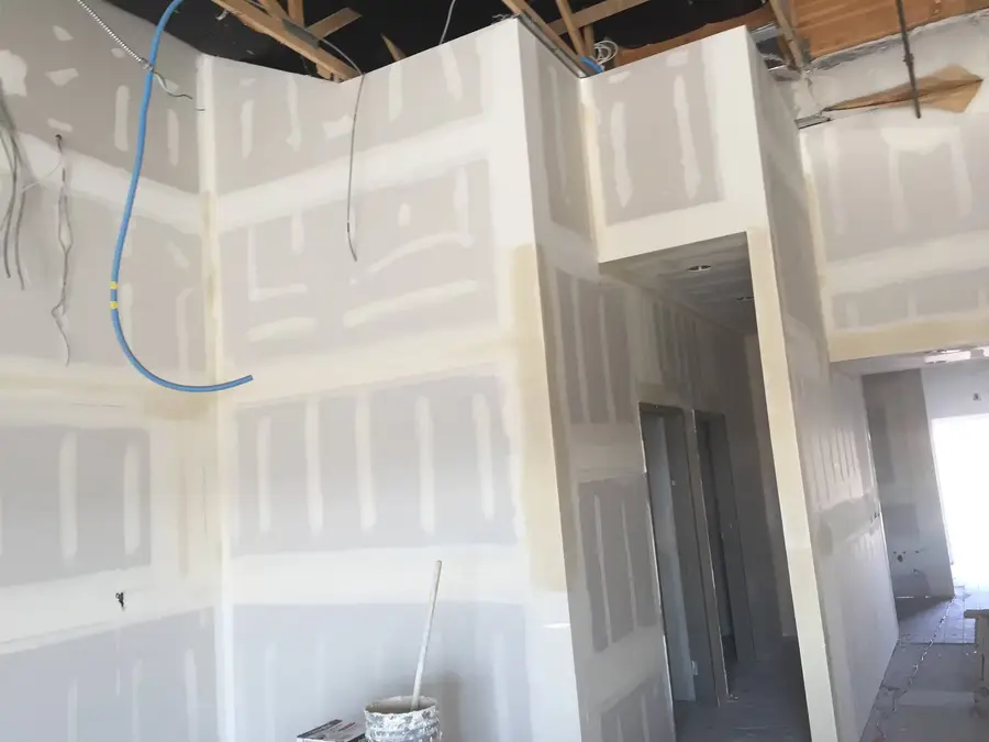 Taped and mudded drywall walls and a hallway framed in during the interior build-out