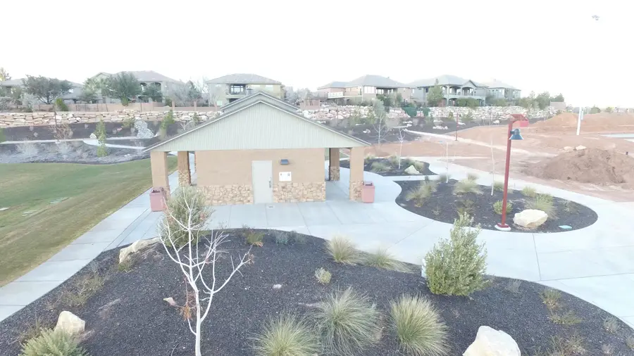 Aerial view of a park restroom building with new sidewalks and landscaping in front of a row of homes