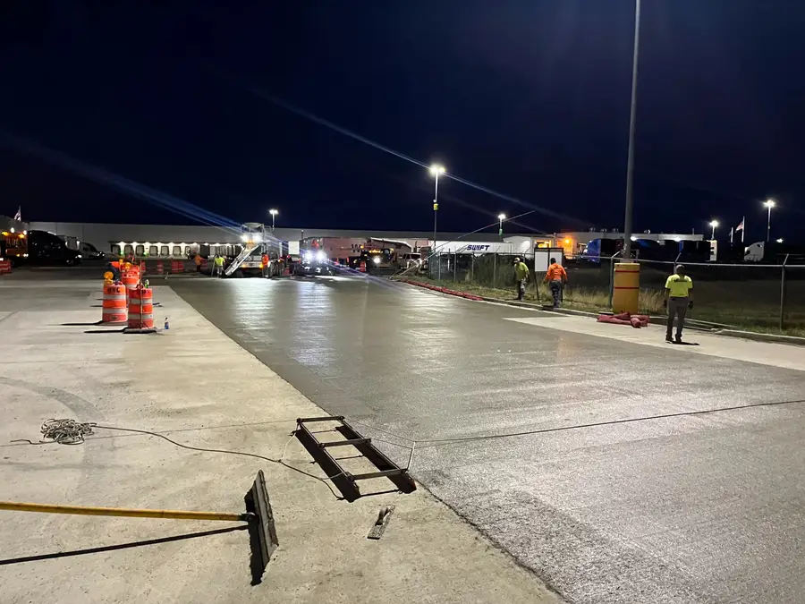 Finished concrete slab under the lights of a Walmart distribution center yard at night