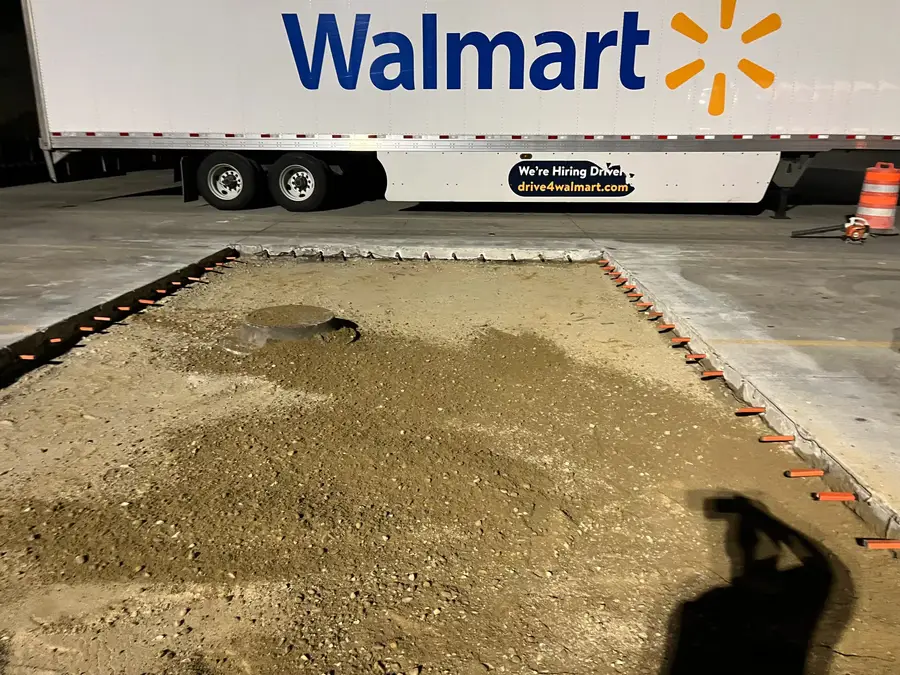 Prepared gravel base next to Walmart trailers before the concrete pour