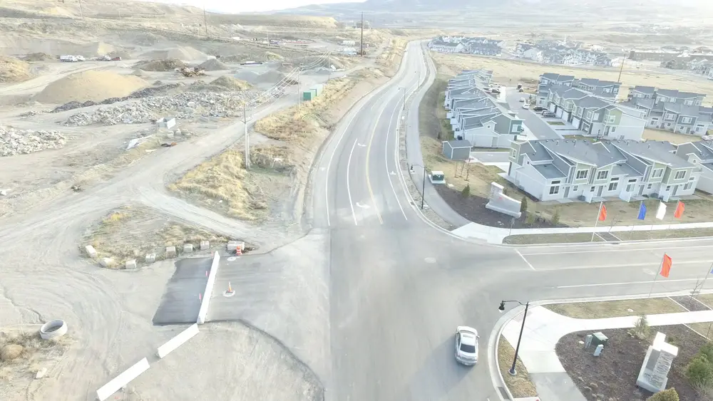 Aerial view of a new B Hansen Construction roadway with curb, gutter and sidewalk through a growing neighborhood