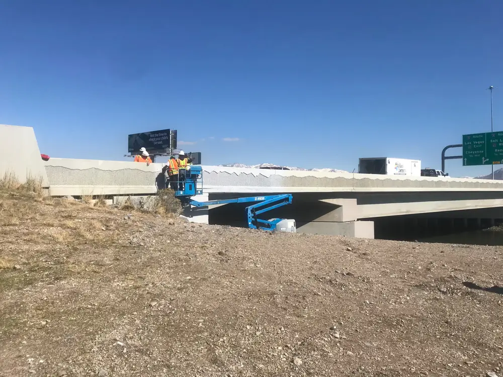 B Hansen Construction crew on a lift working on a highway overpass