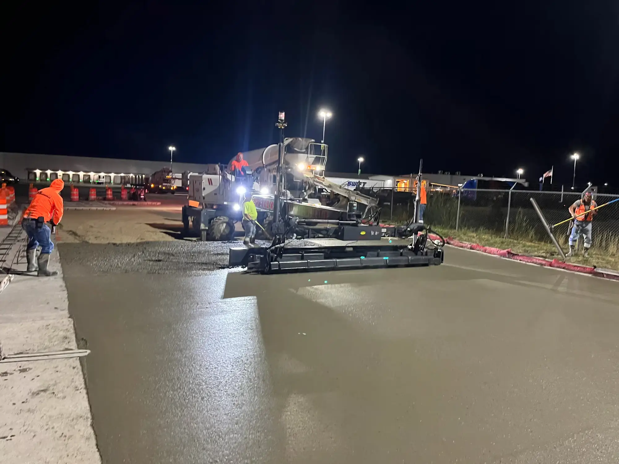 A B Hansen Construction slipform paver placing concrete at a Walmart distribution center at night