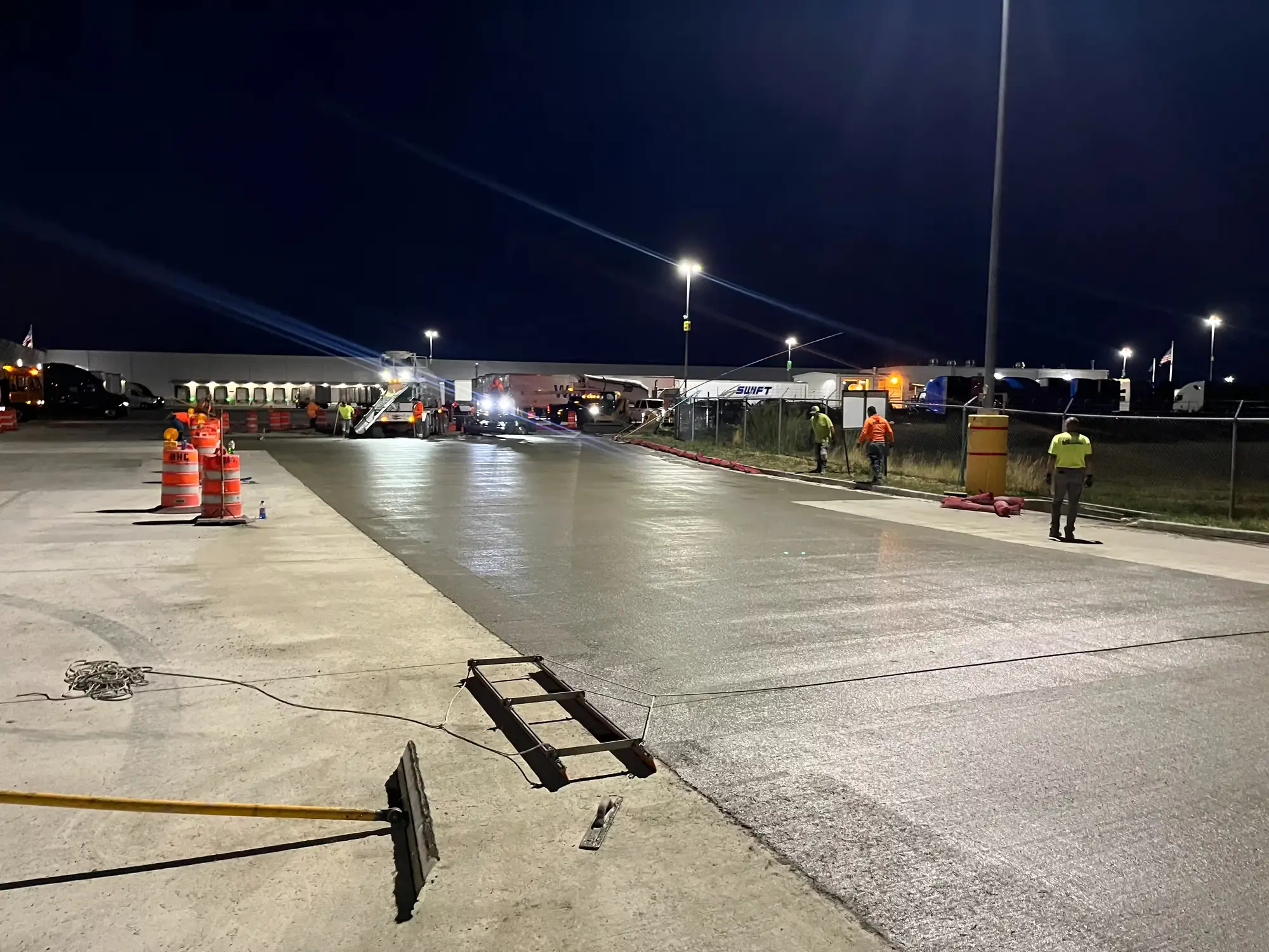 B Hansen Construction crew finishing a new concrete slab at night at a distribution center